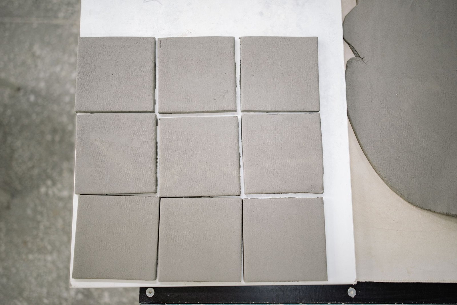 Rows of freshly cut clay slabs laid out on a workbench
