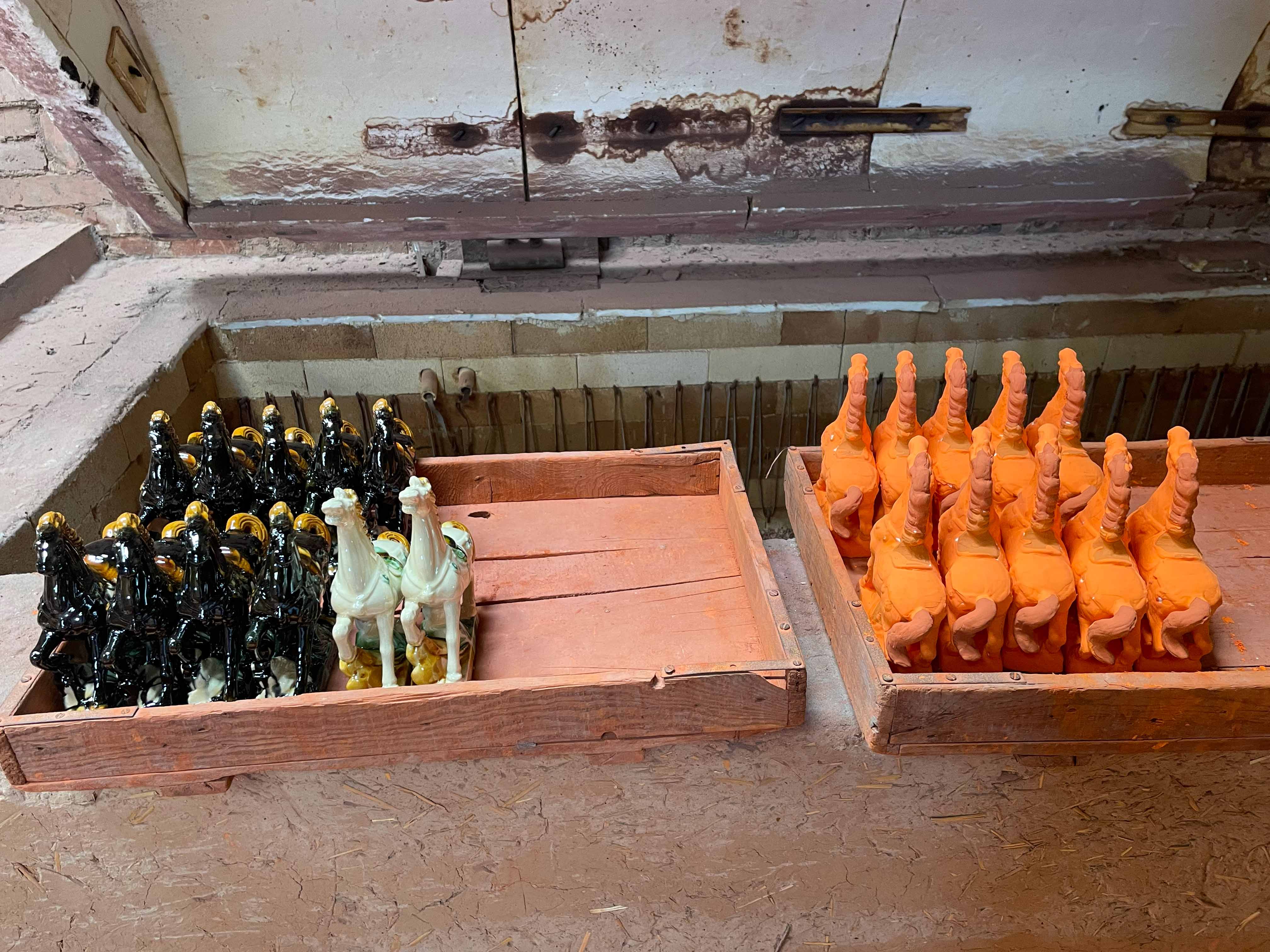Rows of glazed ceramic pieces waiting to be fired