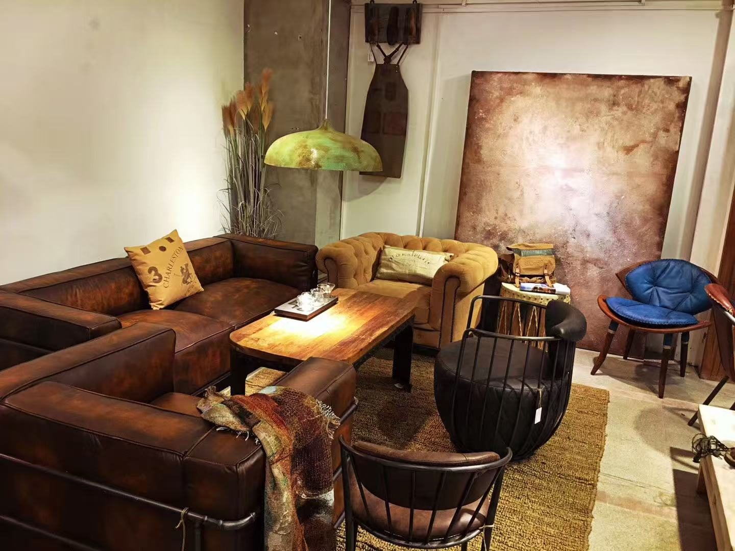 Large rust-toned abstract painting above a leather sofa